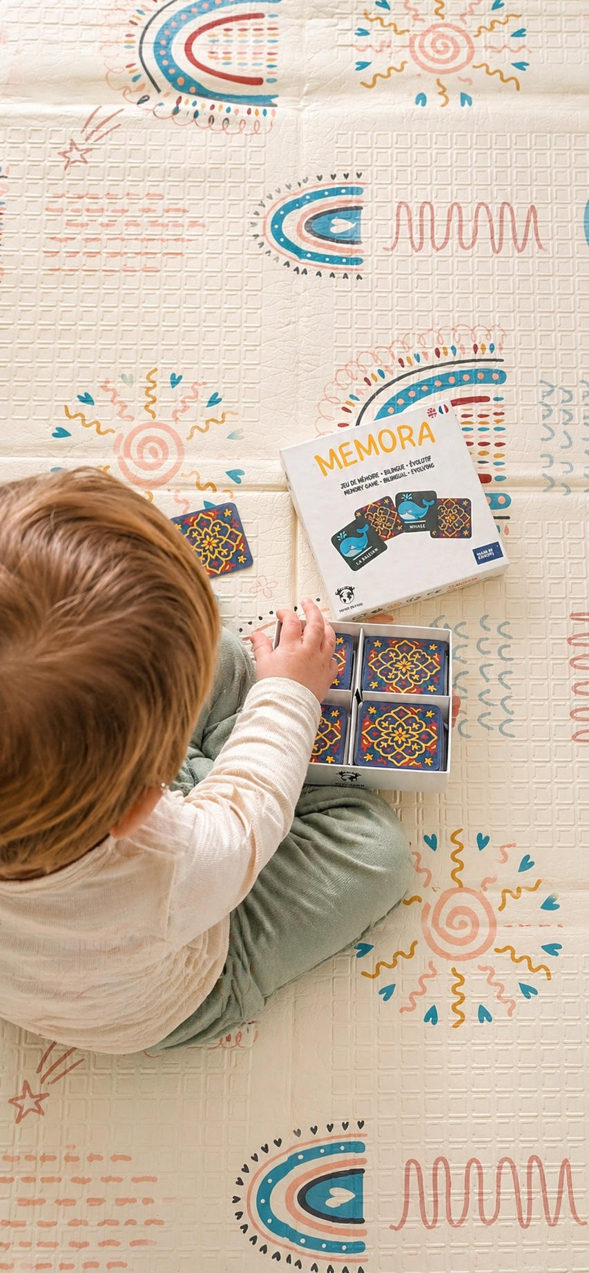 Enfant jouant au jeu MEMORA Français-Anglais en famille