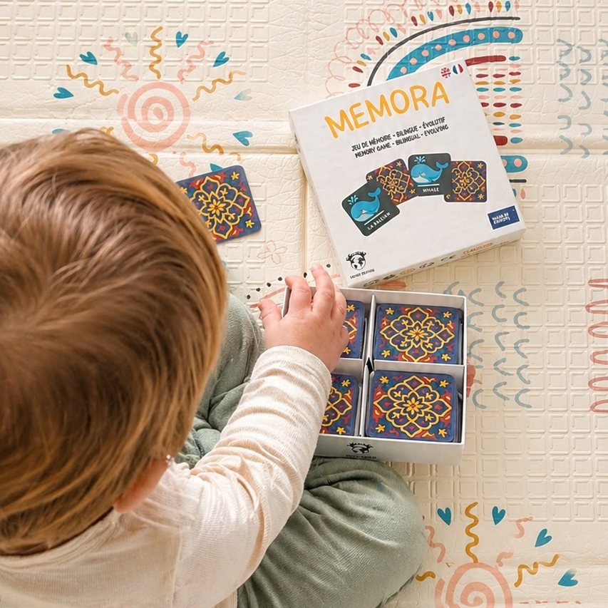 Enfant jouant au jeu bilingue MEMORA Français-Anglais en famille